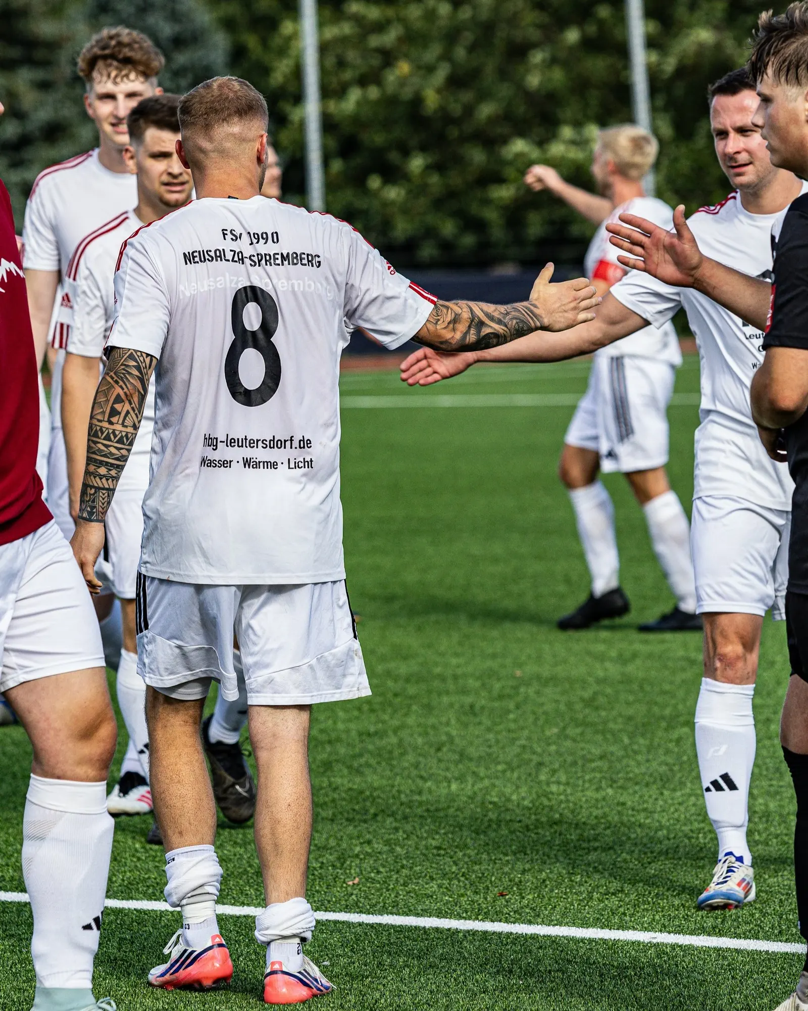Spieler mit der Nummer 8 klatscht einen Mitspieler ab.