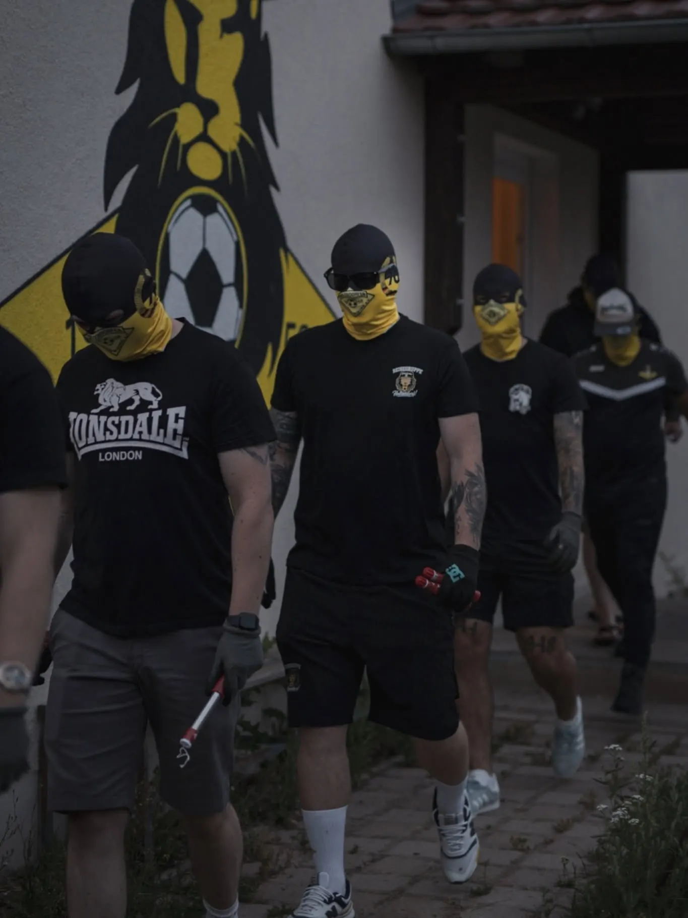 Gruppe mit gelben Sturmhauben vor dem Vereinsheim.