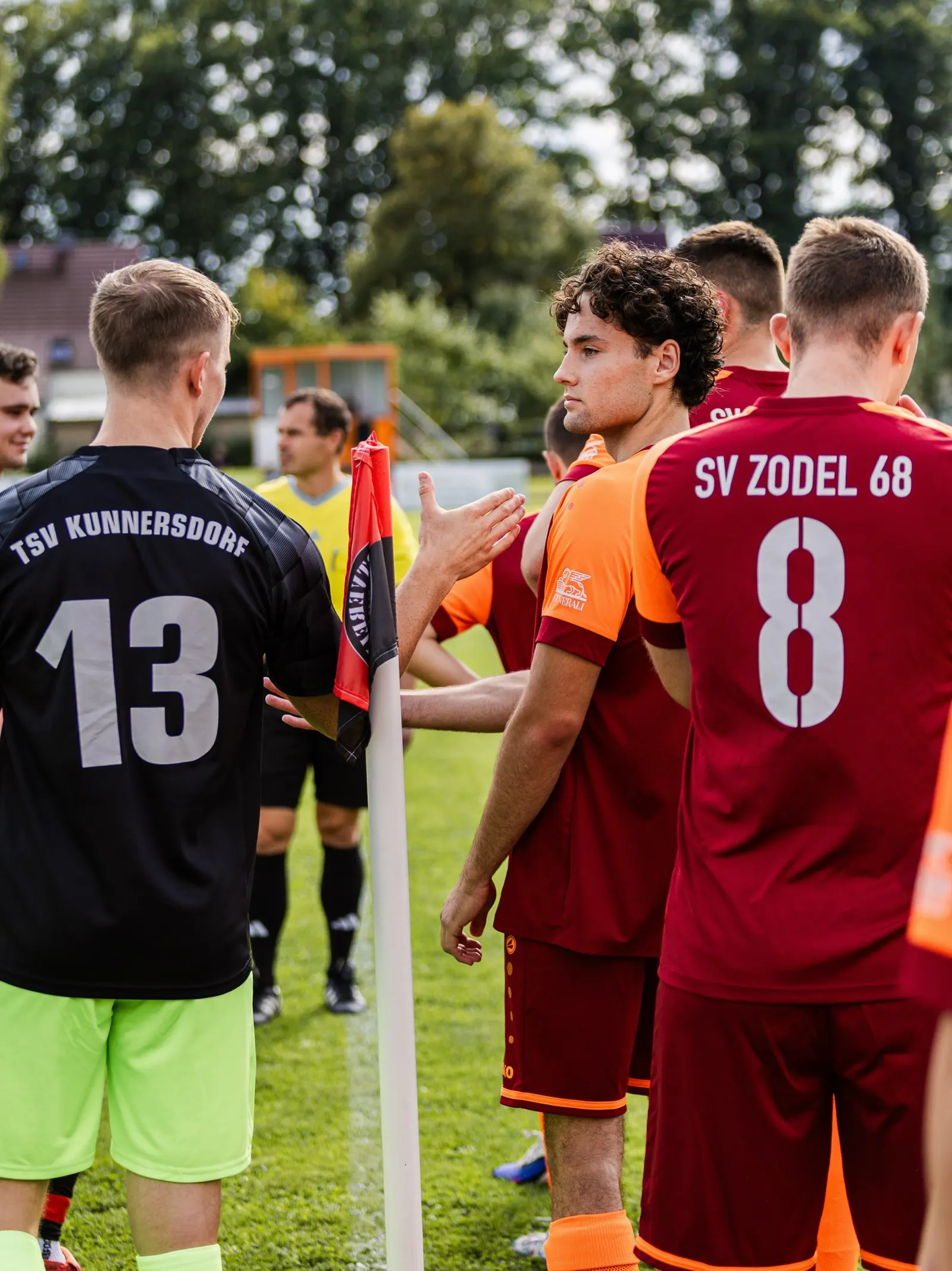 Spieler beider Teams an der Eckfahne, vorne die Rückennummern 13 und 8.